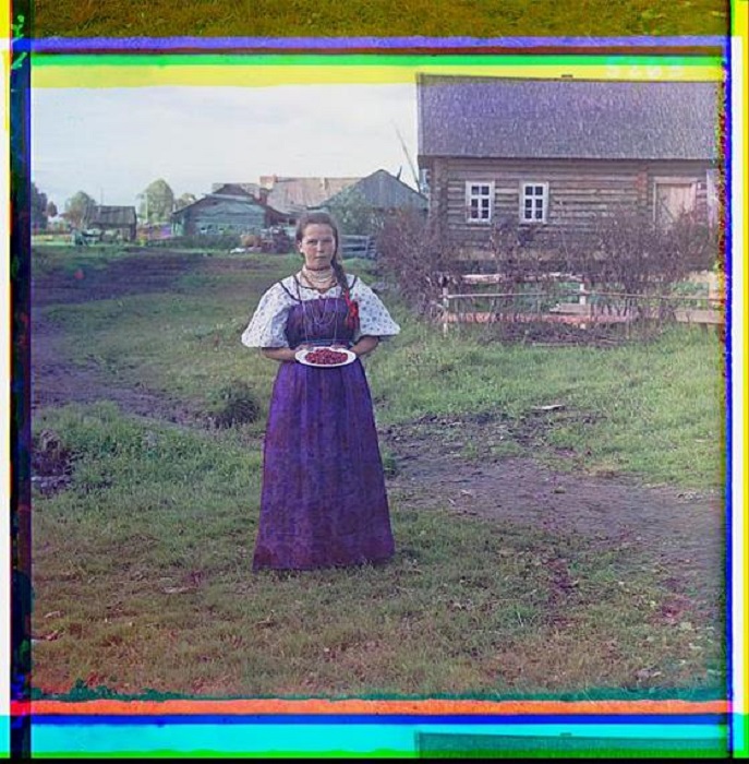 Крестьянка на фоне традиционного деревянного дома в посёлке Кириллов. Крестьянка на фоне традиционного деревянного дома в посёлке Кириллов.