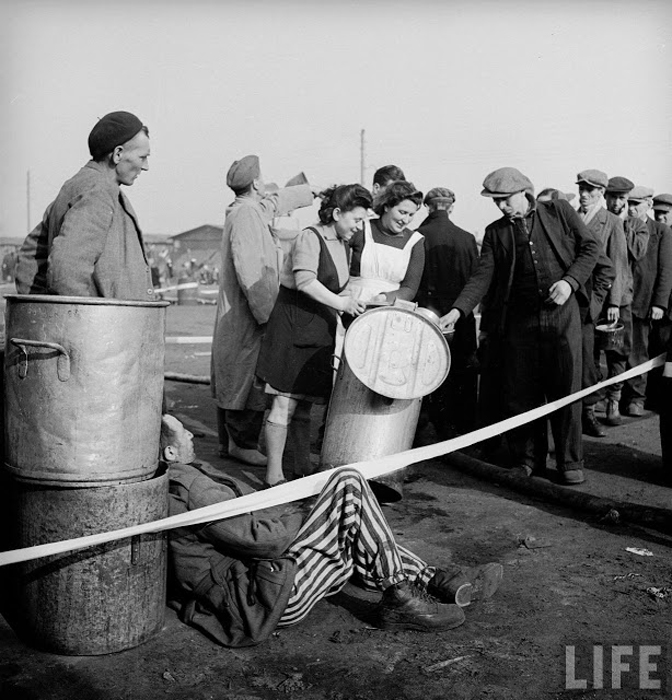 Только что освобожденные заключенные стоят в очереди за едой.