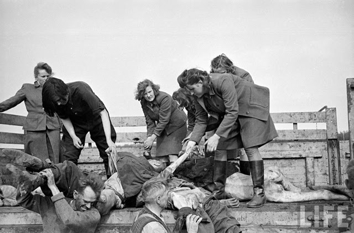 Женский состав охраны концлагеря заставляют разгружать грузовики, заполненные телами.