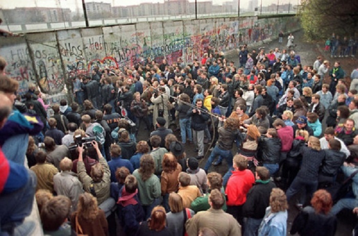 11 ноября, 1989 года, жители западного Берлина смотрят как люди стараются разрушить секцию стены, что открыть новый проход для пересечения границы.