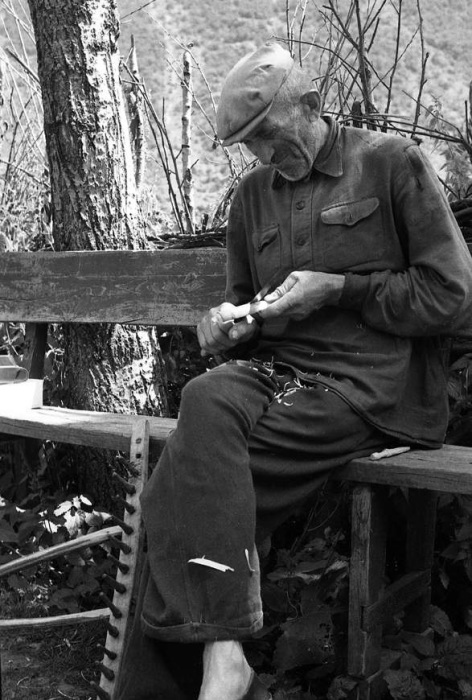 Пожилой мужчина чинит грабли, 1963 год.