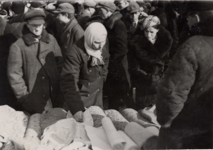 Женщина рассматривает ткань на сельском базаре, 1939 год.