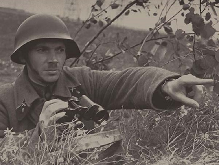 Командир артиллерийского подразделения наблюдает за врагом.