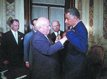 Никита Хрущёв прикрепляет к груди Гамаля Абделя Насера орден Ленина и Золотую звезду Героя Советского Союза. Переводчик – Юлий Султанов (наполовину закрыт фигурой Хрущёва). 12 мая 1964