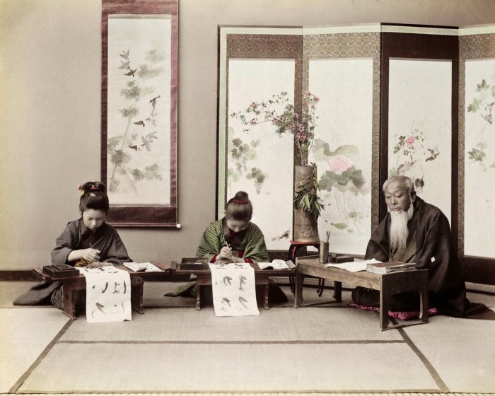 Девушки учатся каллиграфии у мастера-каллиграфа.