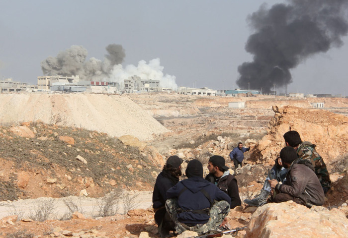 Боевики Свободной Сирийской армии на фоне горящий коммуникаций на окраине сирийского города Алеппо.