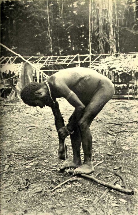 Мужчина добывает огонь трением бечевки по дереву. Мужчина добывает огонь трением бечевки по дереву.