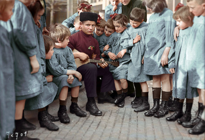Мальчик в народной одежде с группой детей.