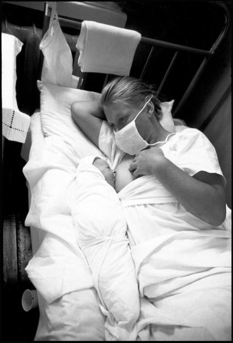 Мать, кормящая грудью малыша в роддоме. СССР, 1966 год. Мать, кормящая грудью малыша в роддоме. СССР, 1966 год.
