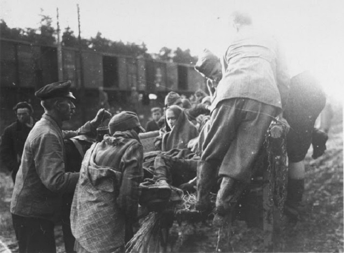 Солдат помогает обессиленному военнопленному подняться в кузов машины. Солдат помогает обессиленному военнопленному подняться в кузов машины.