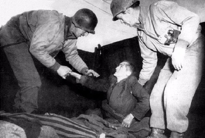 Заключенный из концлагеря пожимает в благодарность руку своему спасителю. Заключенный из концлагеря пожимает в благодарность руку своему спасителю.