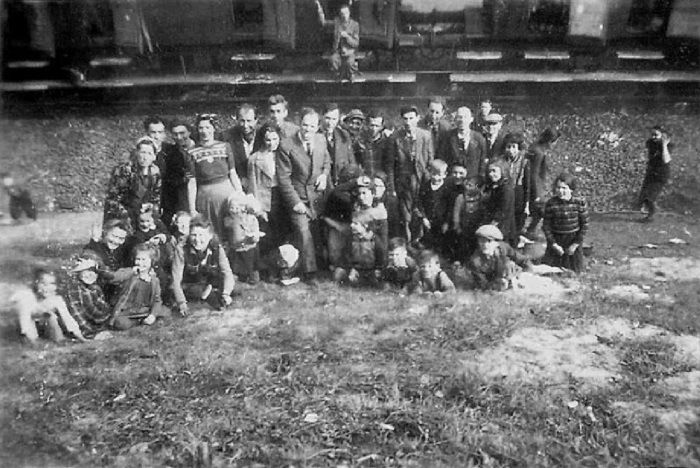 Узники сделали фотографию на фоне стоящего позади поезда смерти. Узники сделали фотографию на фоне стоящего позади поезда смерти.