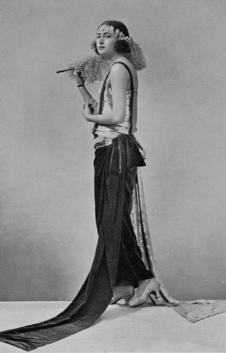 Девушка в льющемся наряде с браслетами и химической завивкой. Девушка в льющемся наряде с браслетами и химической завивкой.