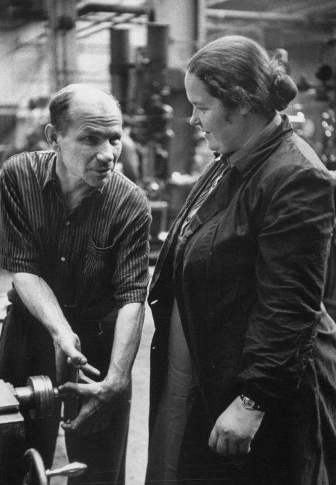 Мужчина, объясняющий женщине принцип работы за станком. СССР, Москва, 1956 год. Мужчина, объясняющий женщине принцип работы за станком. СССР, Москва, 1956 год.