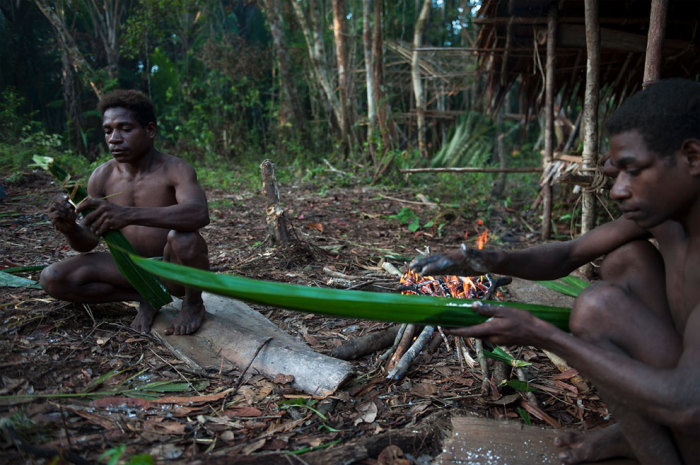 Мужчины подготавливают еду для запекания на костре. Мужчины подготавливают еду для запекания на костре.
