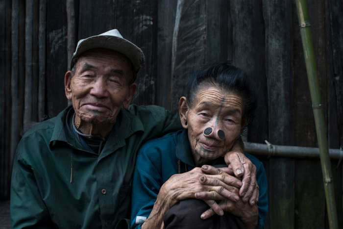 Супружеская пара сидит в обнимку возле своей хижины. Супружеская пара сидит в обнимку возле своей хижины.