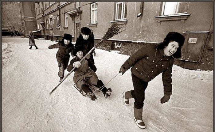 Веселая детвора катает на санках дворника с метлой. Веселая детвора катает на санках дворника с метлой.