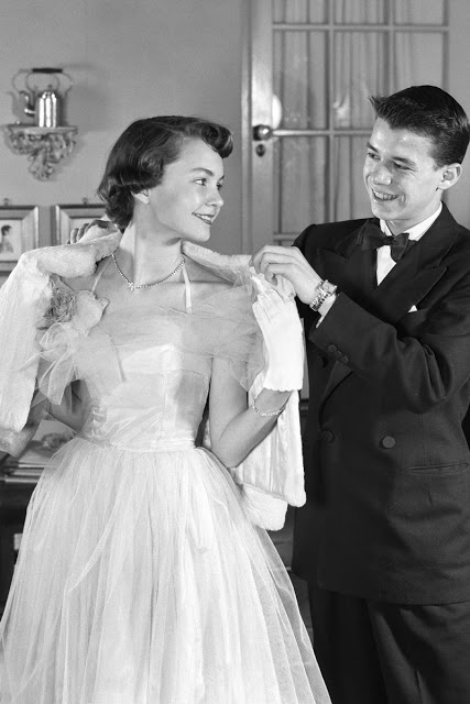 Парень помогает набросить на плечи девушки накидку. Парень помогает набросить на плечи девушки накидку.