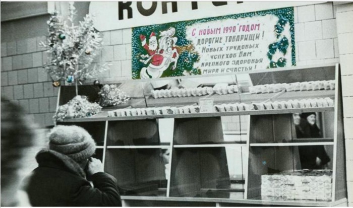 В магазине развешаны новогодние гирлянды и поздравительные плакаты. 1989 год. В магазине развешаны новогодние гирлянды и поздравительные плакаты. 1989 год.