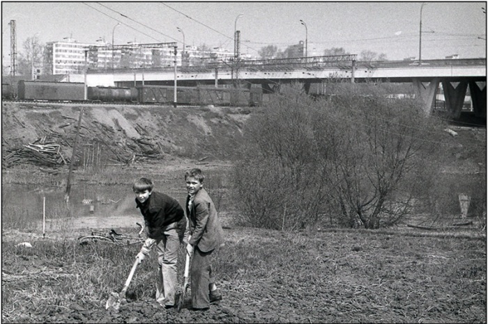 Подростки ухаживают за огородом на пустыре. 