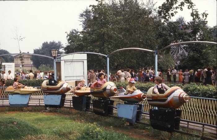 Дети катаются на качелях в центральном парке культуры и отдыха имени Горького.