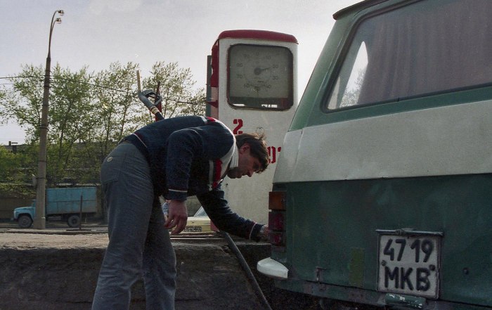 Мужчина заправляющий свой автомобиль на заправочной станции. Мужчина заправляющий свой автомобиль на заправочной станции.