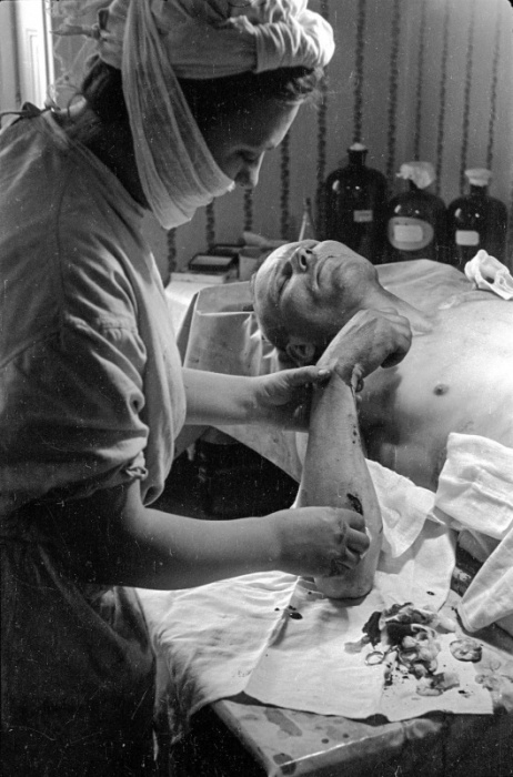 Медик обрабатывает рану на руке советского бойца в госпитале. Медик обрабатывает рану на руке советского бойца в госпитале.