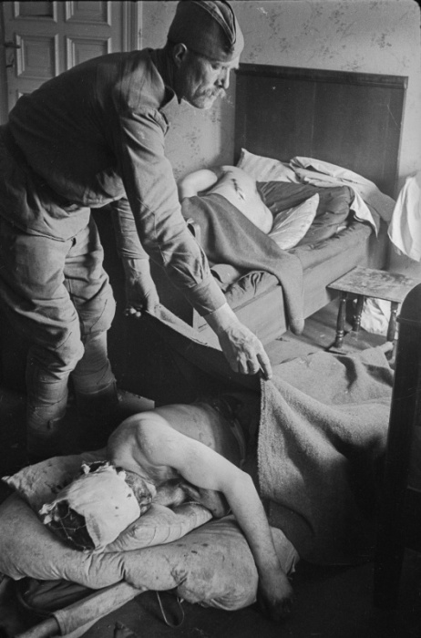 Санитар укрывает одеялом раненого красноармейца в госпитале в Германии. Санитар укрывает одеялом раненого красноармейца в госпитале в Германии.