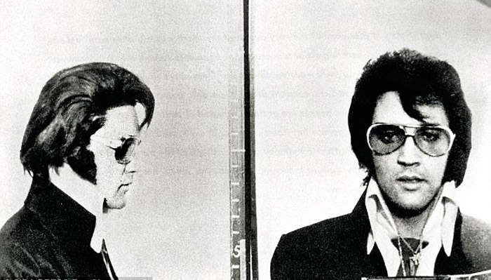 Элвис позирует со значком, который он получил от Денверской Полиции.