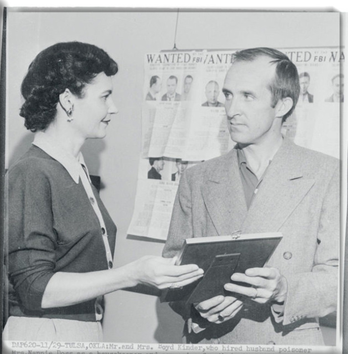 Мистер и миссис Бойд Киндер, нанявшие Нэнни Досс в качестве домработницы и компаньонки для своих троих маленьких детей, смотрят на удостоверение личности в полицейском управлении 29 ноября 1954 года. 